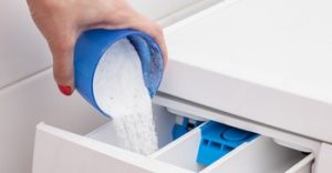 Woman pouring washing powder into the washing machine